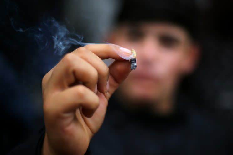 A man holds up a marijuana cigarette during a rally against drug trafficking and in favour for the legalization of self-cultivation of marijuana for medicinal and recreational purposes in Santiago, Chile April 20, 2017. (Photo: Ivan Alvarado/Reuters)