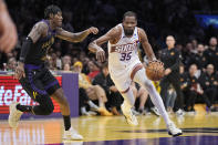 Phoenix Suns forward Kevin Durant, right, drives toward the basket as Los Angeles Lakers forward Jarred Vanderbilt defends during the second half of an NBA basketball In-Season Tournament quarterfinal game Tuesday, Dec. 5, 2023, in Los Angeles. (AP Photo/Mark J. Terrill)