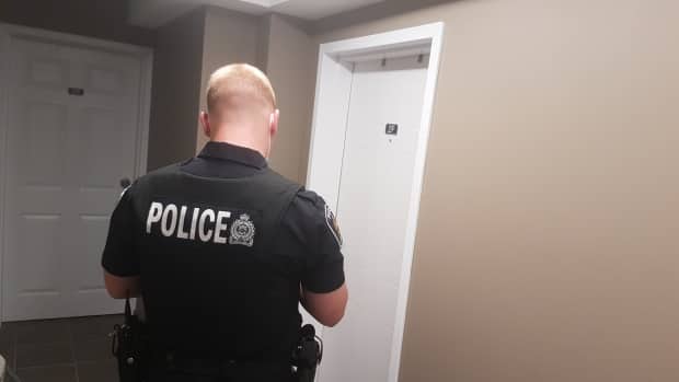 A police officer stands outside the apartment of the London, Ont., man charged in the attack on a Muslim family Sunday that has left four of them dead, with a nine-year-old boy still in hospital. 'He couldn't keep a straight eye contact with you,' a neighbour says of the accused. (Mark Gollom/CBC - image credit)