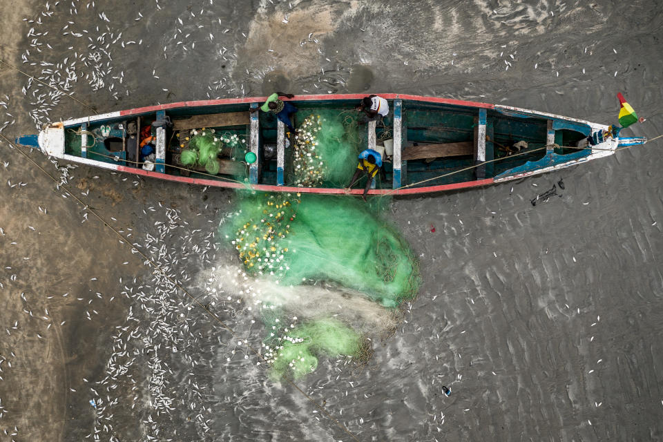 An aerial shot of a Gambian fishing boat with Gambian fishermen. (Fábio Nascimento / The Outlaw Ocean Project)