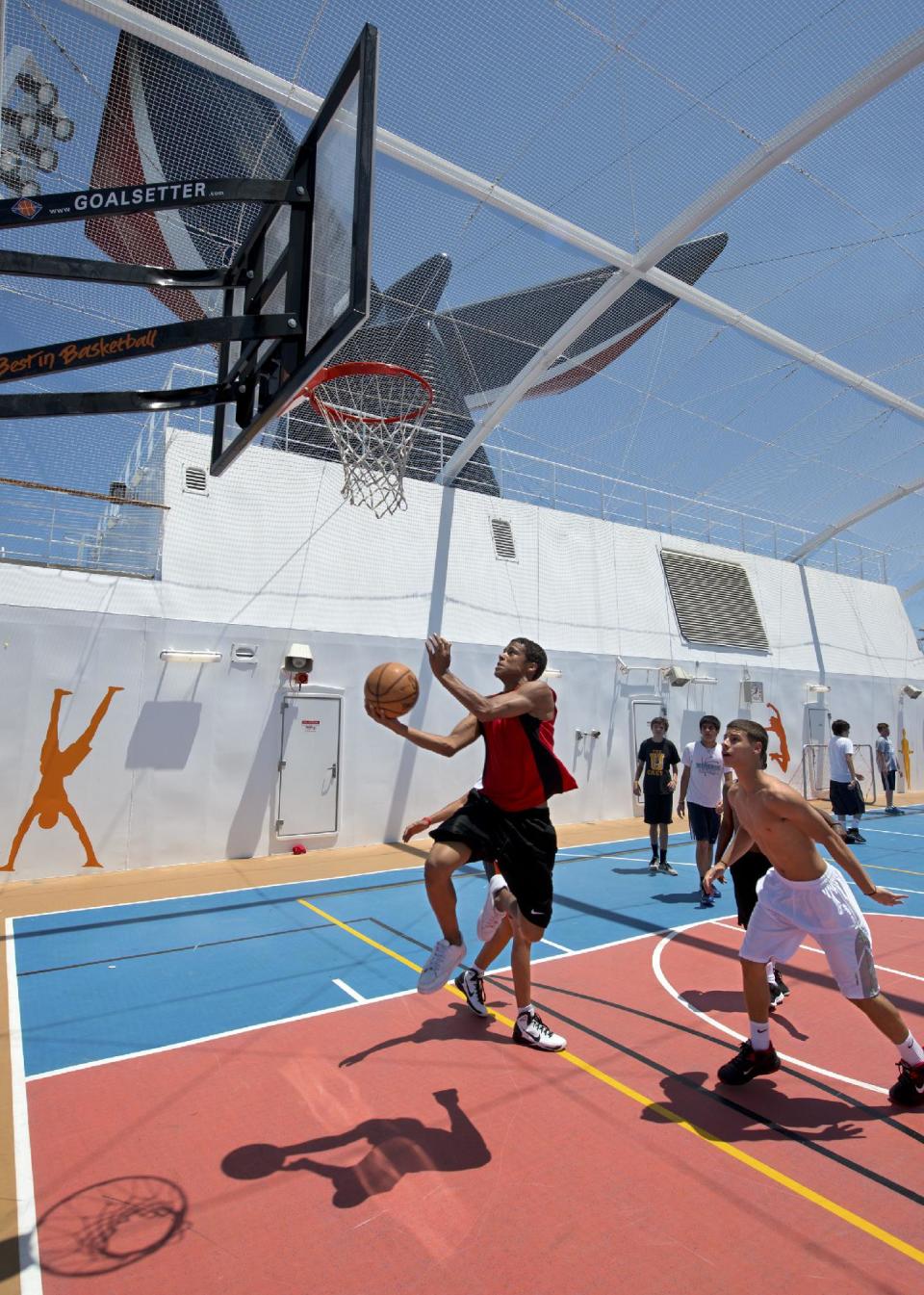 In this June 20, 2012 photo provided by Carnival Cruise Lines, teens on Carnival Cruise Lines' Carnival Breeze play basketball in the ship's expansive SportSquare, an open-air recreation complex that also features a suspended ropes course, mini-golf, jogging track, ping-pong, pool, and foosball tables and more. (AP Photo/Carnival Cruise Lines, Andy Newman)