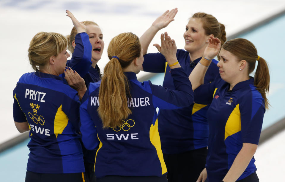Sweden players, clockwise from left, Maria Prytz, Margaretha Sigfridsson, Christina Bertrup, Maria Wennerstroem and coach Agnes Knochenhauer celebrate their victory over Switzerland in the women's curling semifinal game against at the 2014 Winter Olympics, Wednesday, Feb. 19, 2014, in Sochi, Russia. (AP Photo/Robert F. Bukaty)