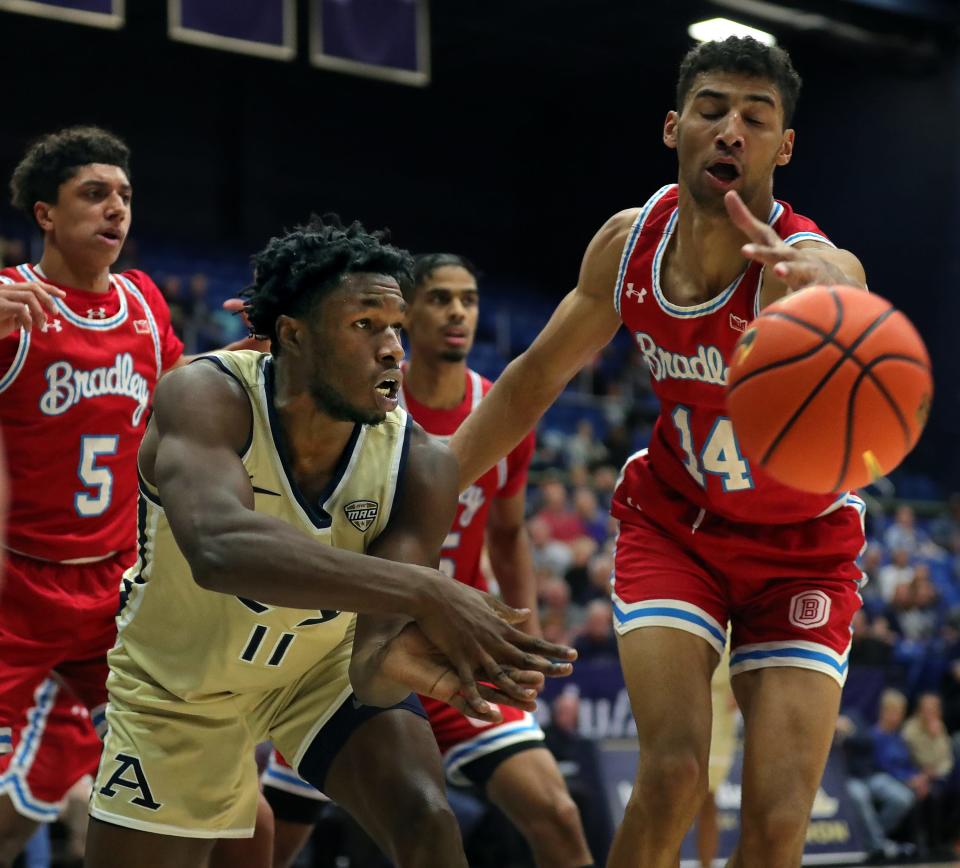 Akron Zips forward Sammy Hunter makes a pass around Bradley forward Malevy Leons (14), Tuesday, Dec. 5, 2023.