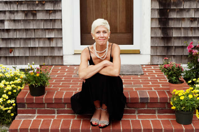 A3EFJJ Portrait of a senior woman sitting at the front stoop of house senior retirement home