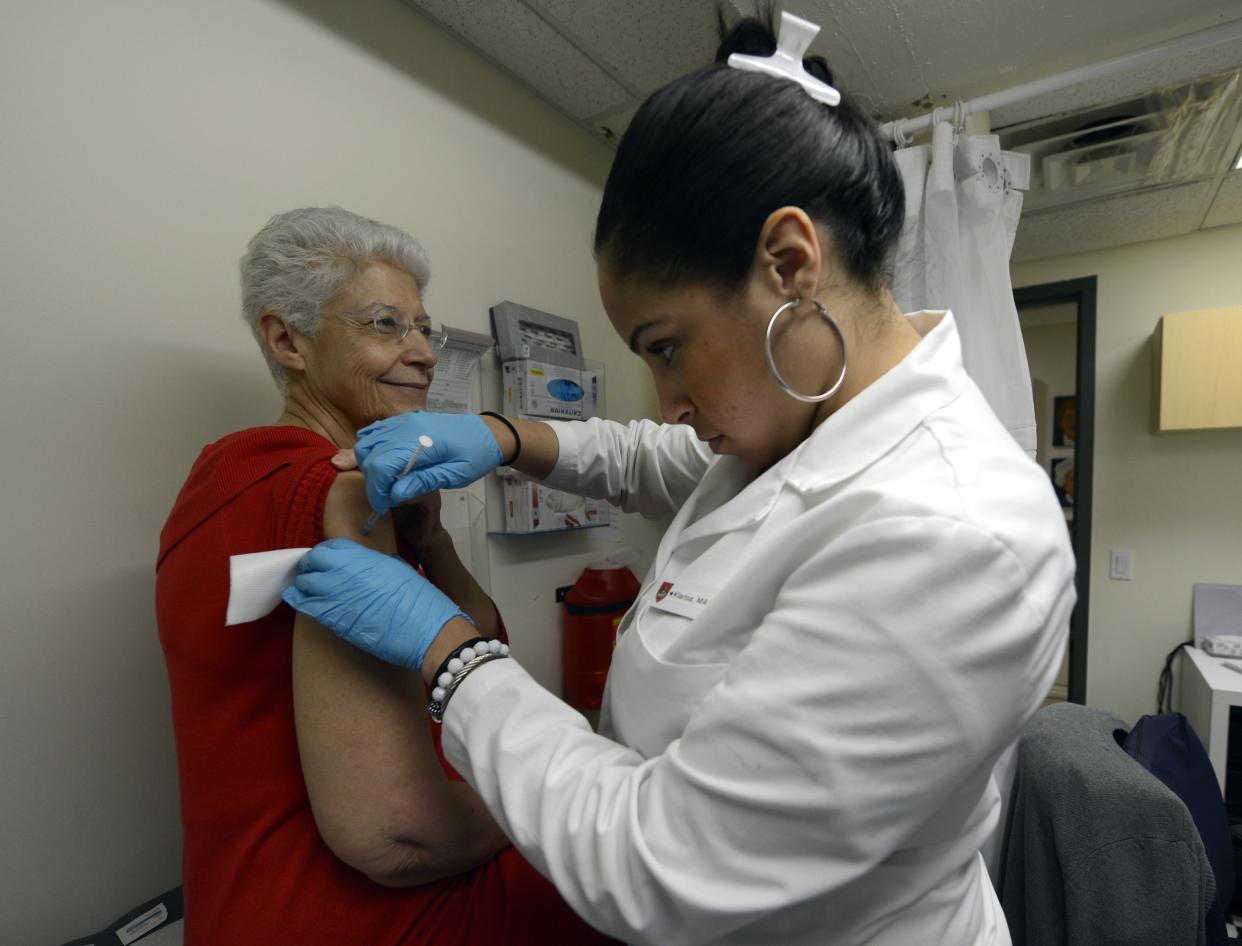 A patient receives a flu shot from a medical professional.