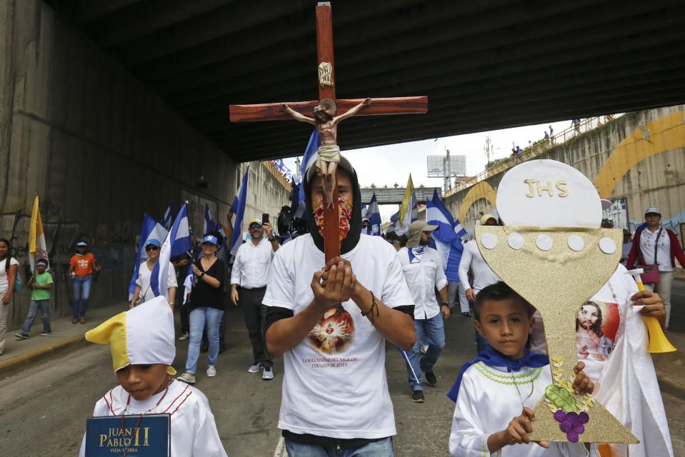 Anti-government demonstrators march holding religious symbols during a march in support of the Catholic church amid recent attacks by pro-government groups, in Managua, Nicaragua, Saturday, July 28, 2018. At least 448 people have been killed, most of them protesters, since the protests began in April. Demonstrators were initially upset over proposed social security cuts but are now demanding Ortega leave office after a deadly crackdown by security forces and armed pro-government civilians. (AP Photo/Alfredo Zuniga)