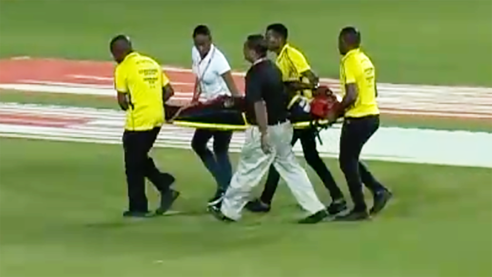Andre Russell, pictured here being taken from the field on a stretcher.