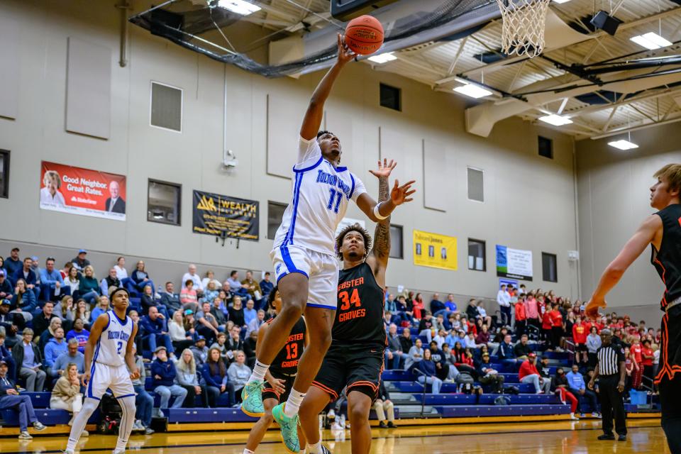 Tolton's Javar Galbreath (11) shoots a layup over Webster Grove's Iziah Purvey (34) during a basketball game at Father Tolton Catholic High School on Dec. 1, 2023, in Columbia, Mo.