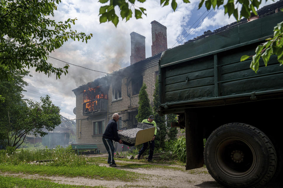 Local residents save their belongings after their house was hit by a Russian airstrike in Vovchansk, Ukraine, on Saturday, May 11, 2024. (AP Photo/Evgeniy Maloletka)