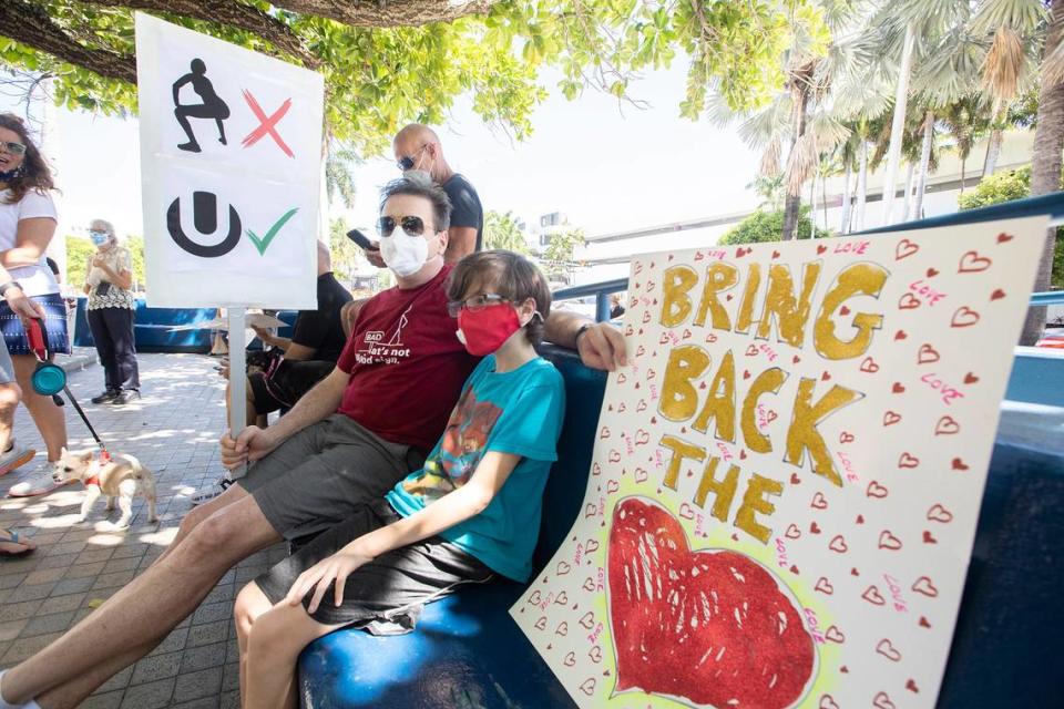 Mike Haynes, 56, and his son Colby, 10, waved signs during a resident rally outside Miami Beach City Hall to protest the city’s handling of spring break on Saturday March 27, 2021.