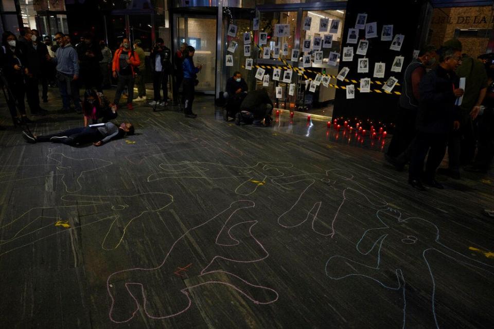 A woman lies on an outline of a body during a vigil to protest the murder of journalist Fredid Roman, outside Mexico's Attorney General's office in Mexico City, Wednesday, Aug. 24, 2022. Roman was the 15th media worker killed so far this year in Mexico, where it is now considered the most dangerous country for reporters outside a war zone. (AP Photo/Eduardo Verdugo)