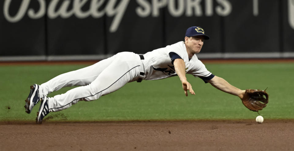 Tampa Bay Rays shortstop Joey Wendle dives for a sharply hit ground ball by Miami Marlins' Lewis Brinson during the first inning of a baseball game Saturday, Sept. 25, 2021, in St. Petersburg, Fla. (AP Photo/Steve Nesius)