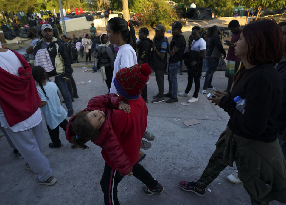 Venezuelan migrants line up to receive a ticket for a date application for asylum in the U.S., in Matamoros, Mexico, Thursday, Dec. 22, 2022. (AP Photo/Fernando Llano)