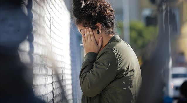 A woman becomes emotional while speaking on the phone near the scene. Photo: Getty Images