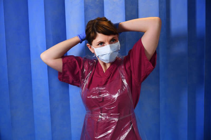 Doctor Nicky Longley puts on her Level 1 PPE at a hospital in London