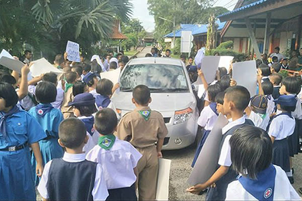 Estudiantes de primaria rodean el coche de la mala maestra contra a que protestan. Foto: Facebook.com/KhaosodEnglish