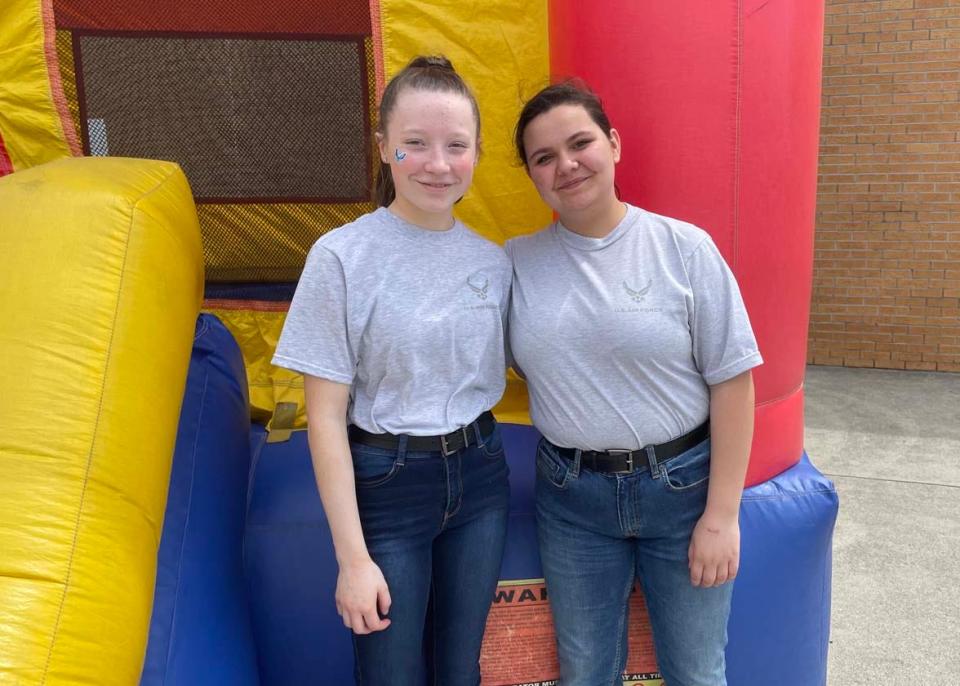 Cadets Abigail Collins, 15, and Carmella West, 14, keep a watchful eye out on the kids playing in the inflatable castle at the fourth annual Community Bazaar at Karns High School Saturday, April 30, 2022.