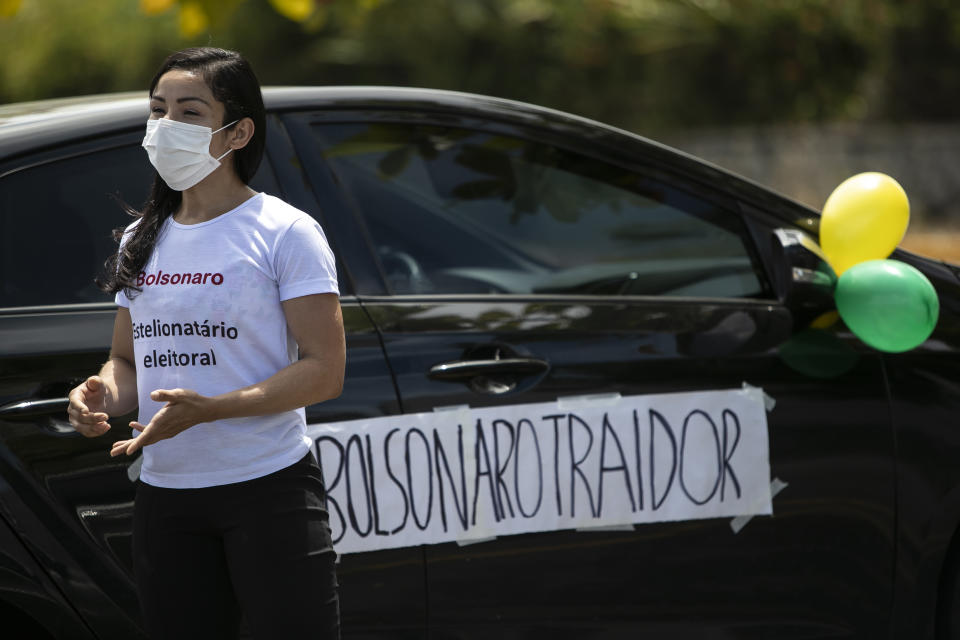 With a sign that reads in Portuguese "Bolsonaro Traitor," a former supporter of Brazil's President Jair Bolsonaro joins a protest against the government's response in combating COVID-19 and demanding his impeachment, in Rio de Janeiro, Brazil, Sunday, Jan. 24, 2021. (AP Photo/Bruna Prado)