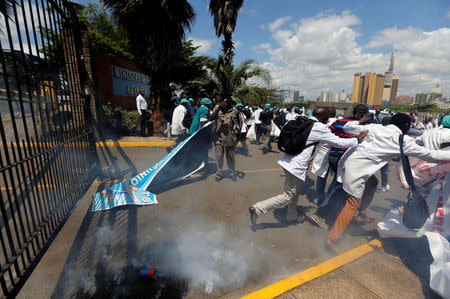 Kenyan doctors run after riot police fired tear gas canisters to disperse them during a strike to demand fulfilment of a 2013 agreement between their union and the government that would raise their pay and improve working conditions outside Ministry of Health headquarters in Nairobi, Kenya December 5, 2016. REUTERS/Thomas Mukoya