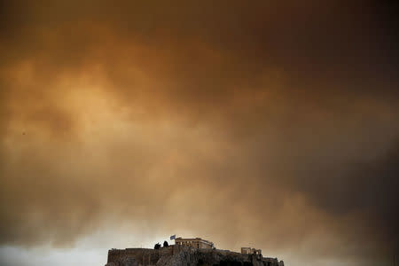 Smoke from a wildfire burning outside Athens is seen over the Parthenon temple atop the Acropolis hill in Athens, Greece, July 23, 2018. REUTERS/Alkis Konstantinidis