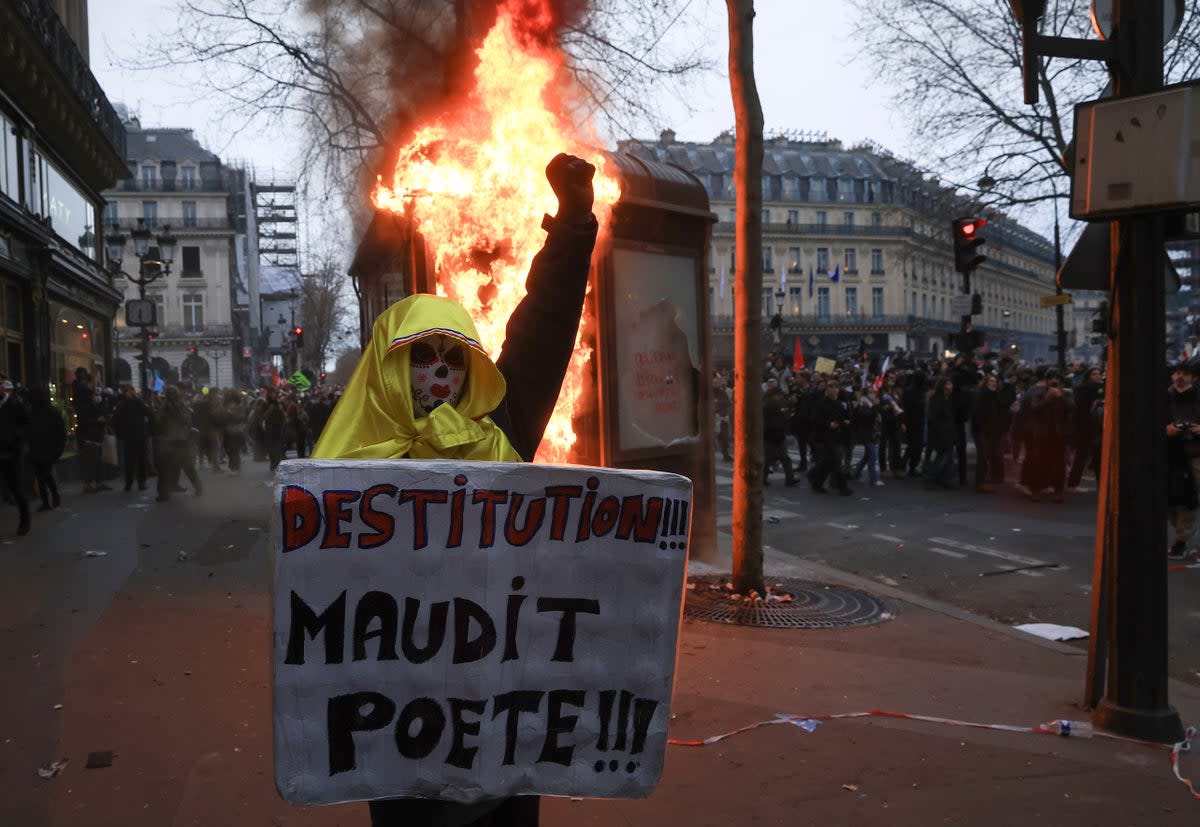 A protester holds a placard that reads ‘destitution of the cursed poet’ during a rally in Paris on Thursday (Copyright 2023 The Associated Press. All rights reserved.)