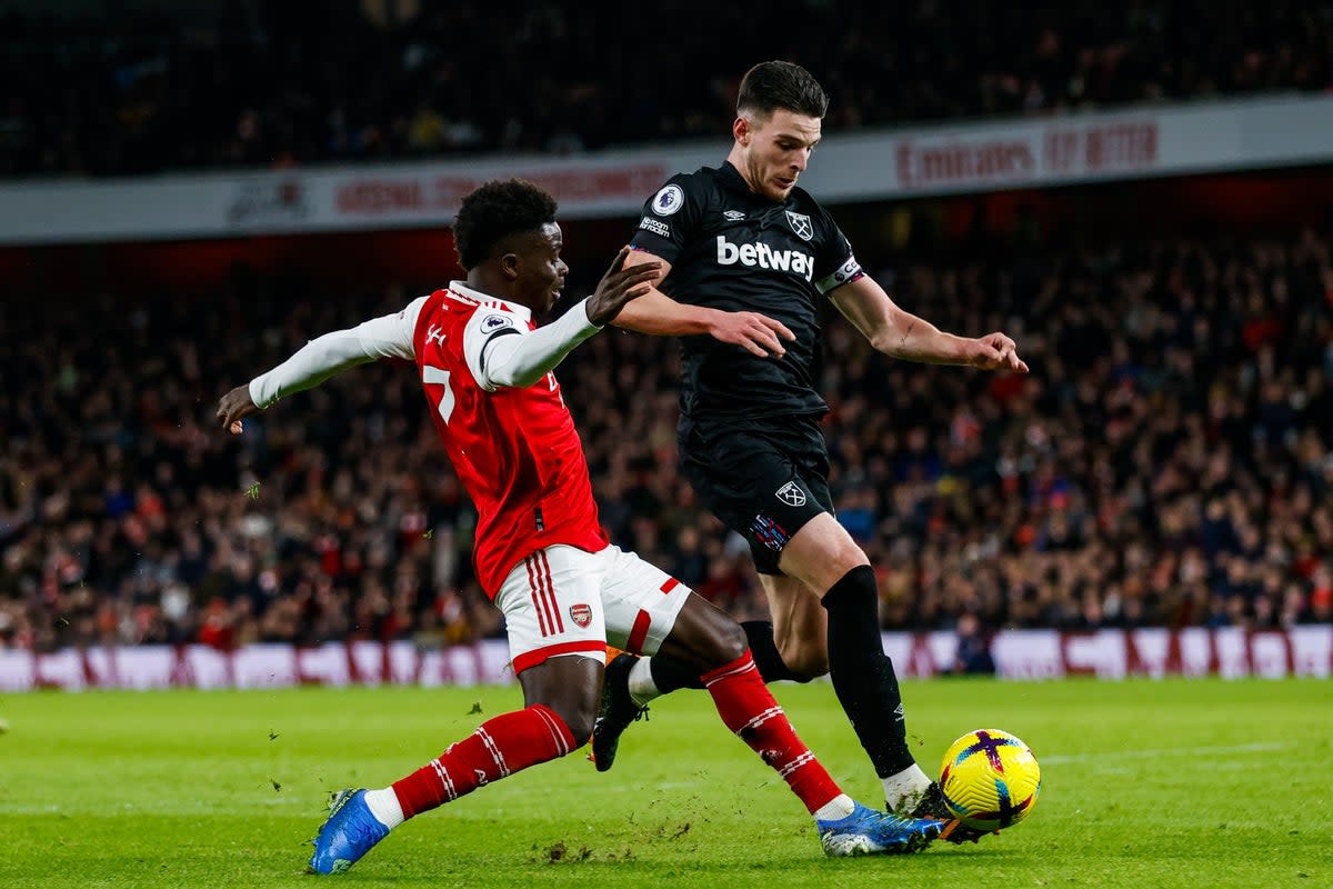 Arsenal’s Bukayo Saka and West Ham United’s Declan Rice battle for the ball during the Premier League match at the Emirates Stadium, London. Picture date: Monday December 26, 2022. (PA Wire)