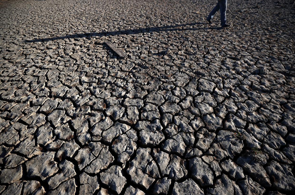 A visitor walks across cracked earth that used to be the bottom of Lake Mendocino on April 22, 2021 in Ukiah, California. (Getty Images)