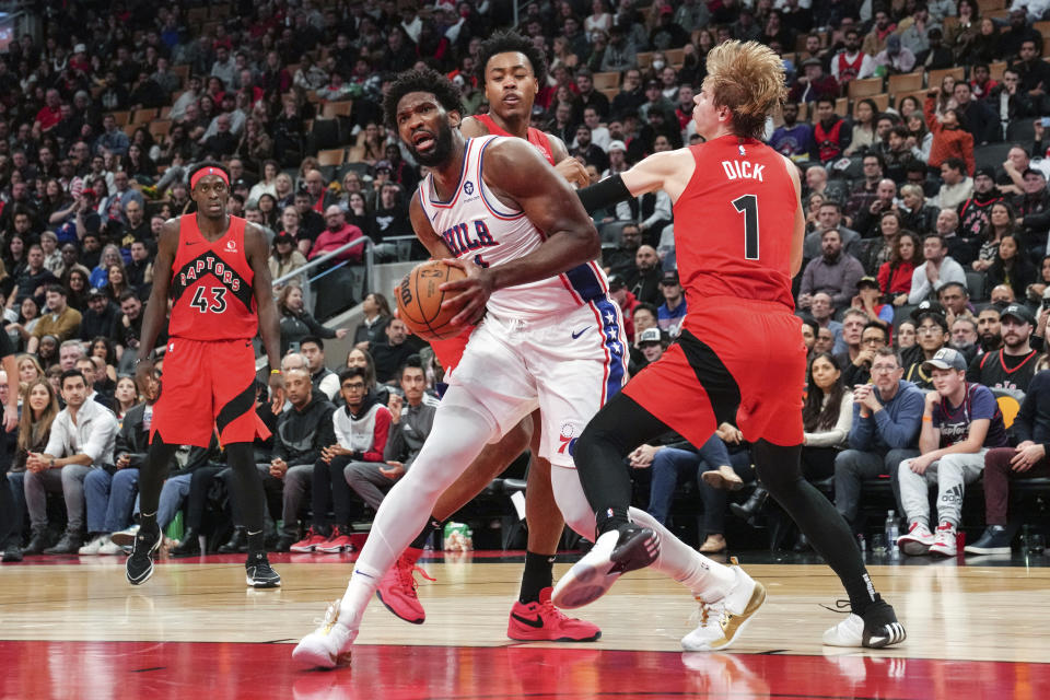 Philadelphia 76ers' Embiid drives past Toronto Raptors' Gradey Dick, right, as Raptors' Scottie Barnes and Pascal Siakam, left, watch during the second half of an NBA basketball game Saturday, Oct. 28, 2023, in Toronto. (Chris Young/The Canadian Press via AP)