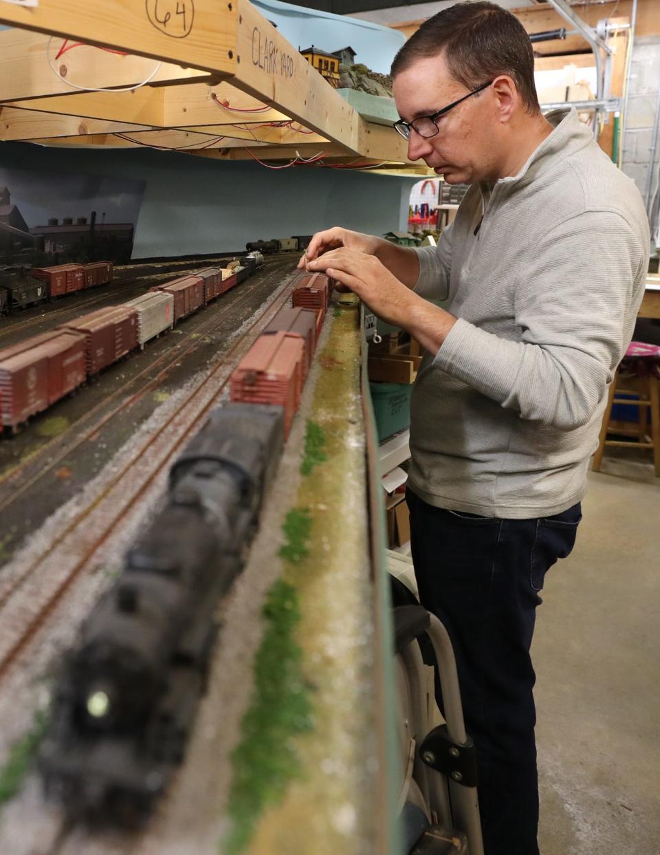 Matthew Albright of the Cuyahoga Valley Terminal Model Railroad Club adjusts a train that had derailed. The club looking for a home for their railroad.