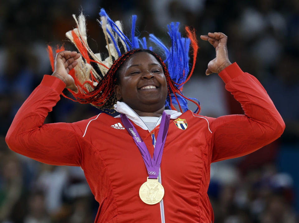 Cuba's Idalys Ortiz reacts after receiving her gold medal for the women's over 78-kg judo competition at the 2012 Summer Olympics, Friday, Aug. 3, 2012, in London. (AP Photo/Paul Sancya) 