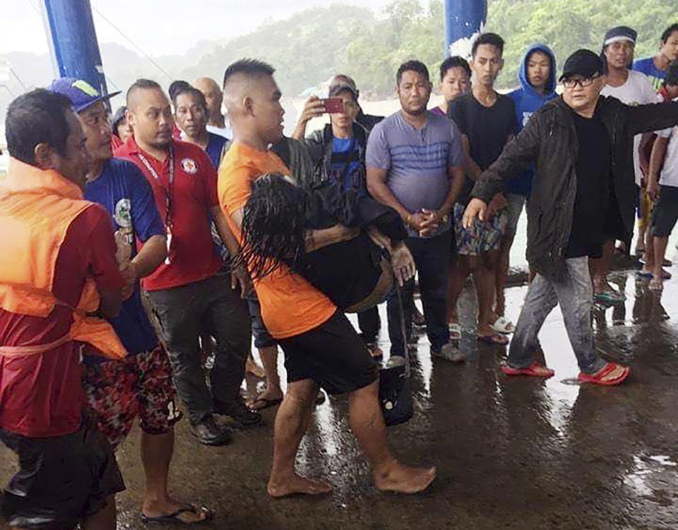 In this photo provided by the Philippine Coast Guard, coast guard rescuers carry a victim alive after being plucked from the waters off Guimaras Sunday, Aug. 4, 2019 in Iloilo province in central Philippines. Philippine police say rescuers have plucked more bodies in rough seas where three ferry boats capsized after being buffeted by fierce wind and waves off two central provinces.(Philippine Coast Guard Photo Via AP)