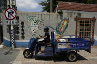 A man rides past by a mural depicting a bridge between China mainland and Taiwan in Pingtan in eastern China's Fujian Province, Sunday, Aug. 7, 2022. Taiwan said Saturday that China's military drills appear to simulate an attack on the self-ruled island, after multiple Chinese warships and aircraft crossed the median line of the Taiwan Strait following U.S. House Speaker Nancy Pelosi's visit to Taipei that infuriated Beijing. (AP Photo/Ng Han Guan)