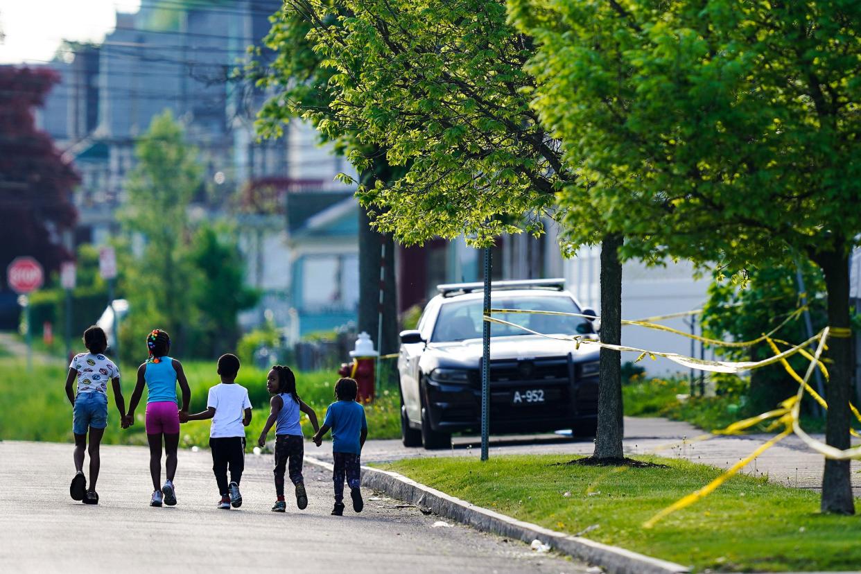 Children walk hand in hand out near the scene of a shooting at a supermarket in Buffalo, N.Y. on Sunday, May 15, 2022.