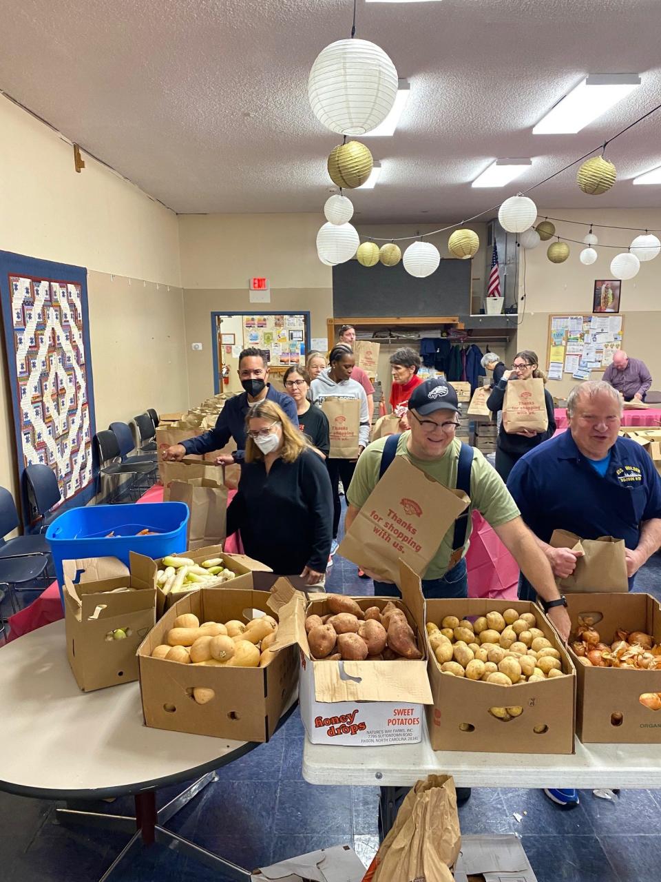 Volunteers pack bags full of Thanksgiving groceries for the "No Cost Market" at Red Hook Community Center.