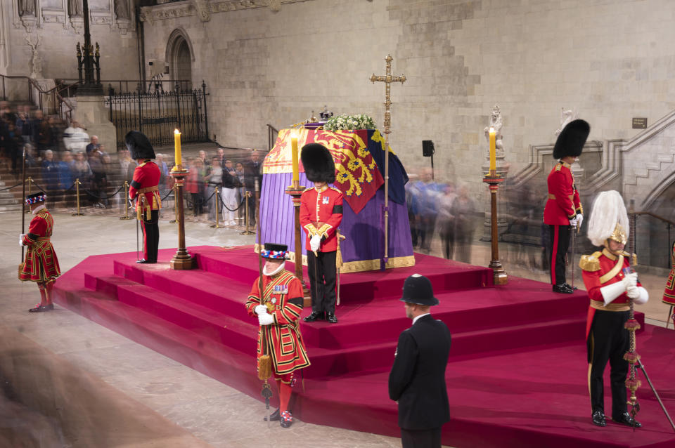 A long exposure photograph showing members of the public as they file past the coffin of Queen Elizabeth II, draped in the Royal Standard with the Imperial State Crown and the Sovereign's orb and sceptre, lying in state on the catafalque in Westminster Hall, at the Palace of Westminster, London, ahead of her funeral on Monday. Picture date: Thursday September 15, 2022.