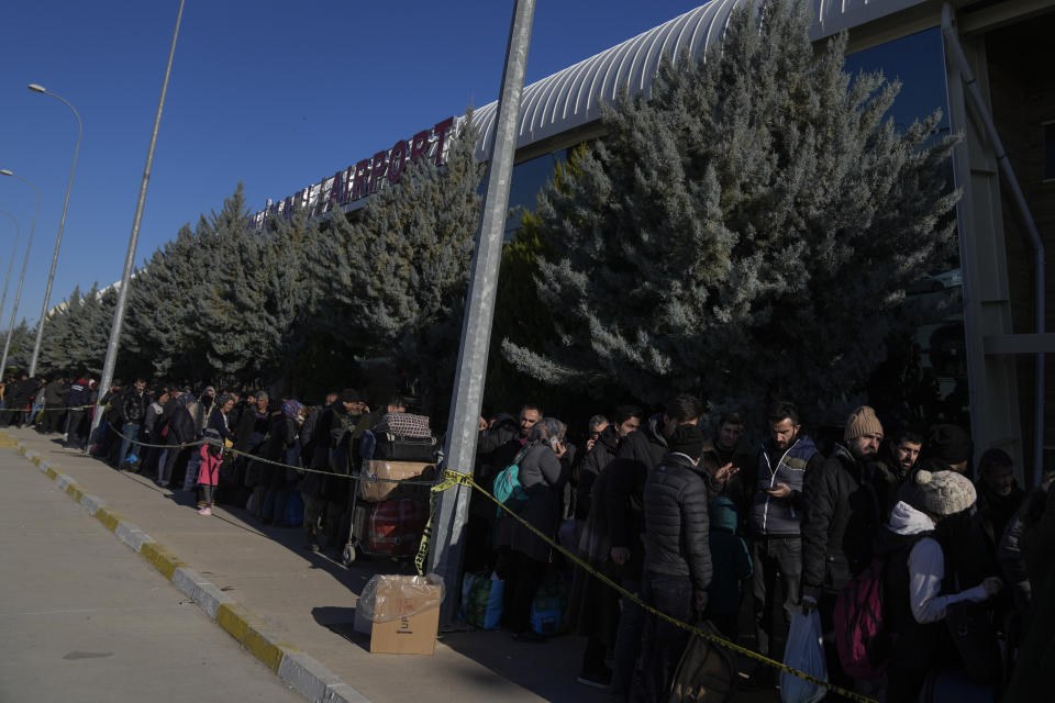 People line up outside Adiyaman domestic airport to leave the city, southern Turkey, Sunday, Feb. 12, 2023. Six days after earthquakes in Syria and Turkey killed tens of thousands, sorrow and disbelief are turning to anger and tension over a sense that there has been an ineffective, unfair and disproportionate response to the historic disaster. (AP Photo/Khalil Hamra)