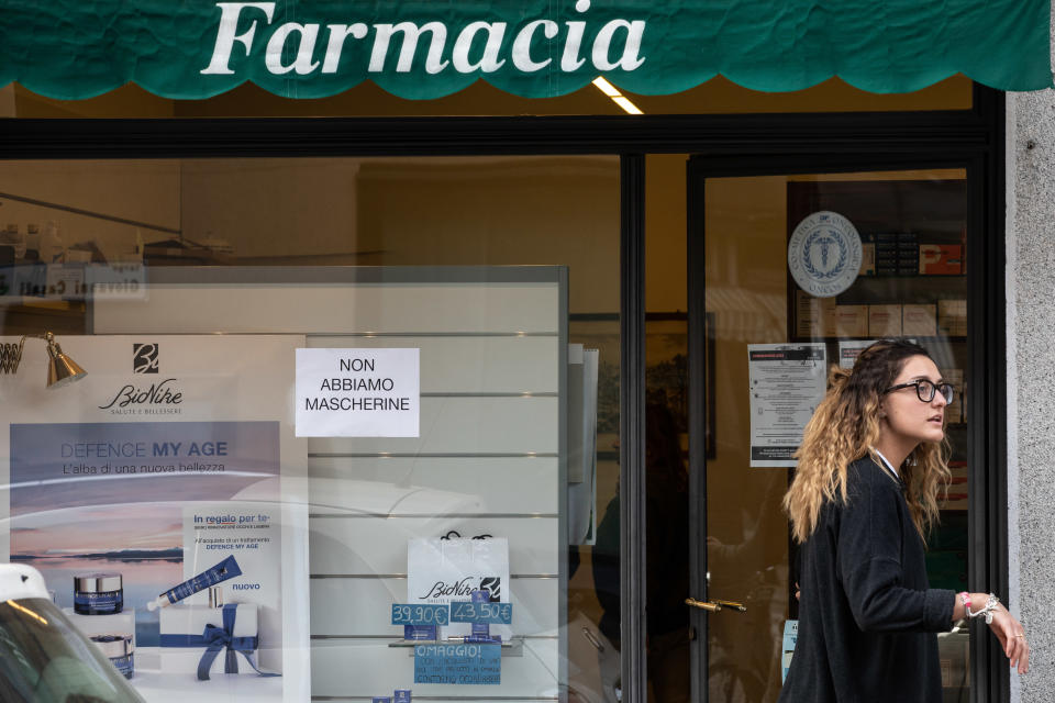 CASALPUSTERLENGO, ITALY - FEBRUARY 23: A young woman stands in front of a pharmacy with a sign on the window reading 'Face masks are over' on February 23, 2020 in Casalpusterlengo, south-west Milan, Italy. Casalpusterlengo is one of the ten small towns placed under lockdown earlier this morning as a second death from coronavirus sparked fears throughout the Lombardy region. (Photo by Emanuele Cremaschi/Getty Images)