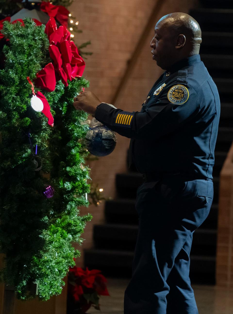 Metro Nashville Police Chief John Drake places an ornament on a wreath to honor victims of homicide during a remembrance ceremony – Season to Remember – at First Baptist Church Thursday, Dec. 7, 2023. Nashville recorded 101 homicides in 2023.