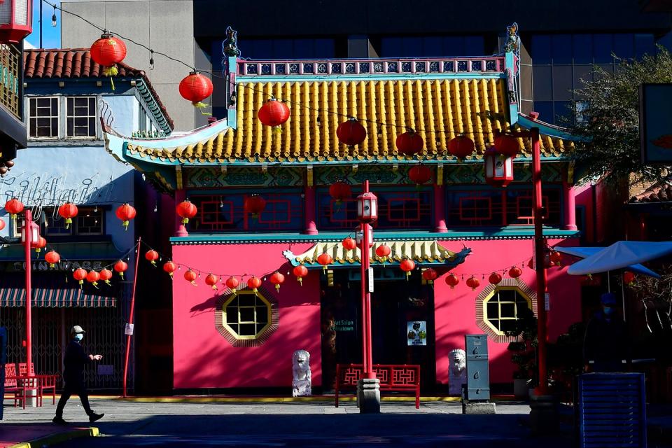 A pedestrian wearing a facemask walks though Chinatown Central Plaza on the first day of the Lunar New Year of the Ox in Los Angeles