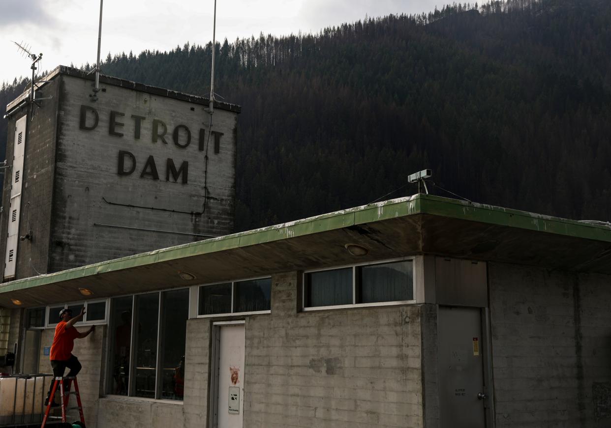 A construction worker in 2020 looks at a light fixture at the Detroit Dam. Oregon's new domestic terrorism law makes it a first degree crime to destroy or substantially damage critical infrastructure such as dams.