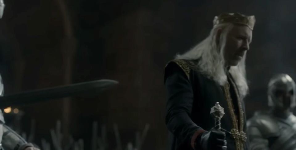 Viserys holds his sword in the throne room