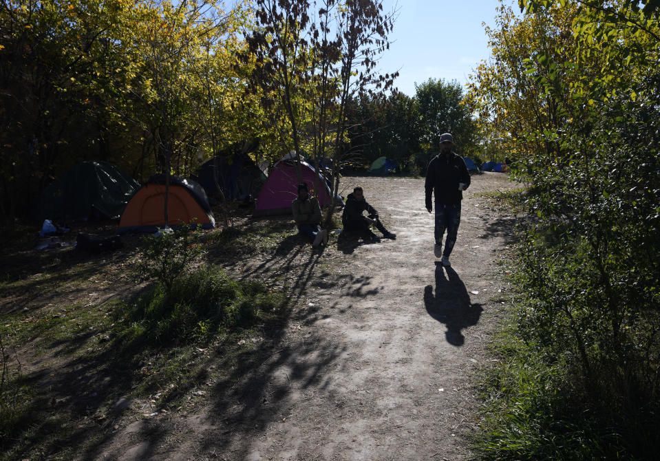 Migrants rest at a makeshift camp near a border line between Serbia and Hungary, near village of Horgos, Serbia, Thursday, Oct. 20, 2022. Located at the heart of the so-called Balkan route, Serbia recently has seen a sharp rise in arrivals of migrants passing through the country in search of a better future in the West. (AP Photo/Darko Vojinovic)