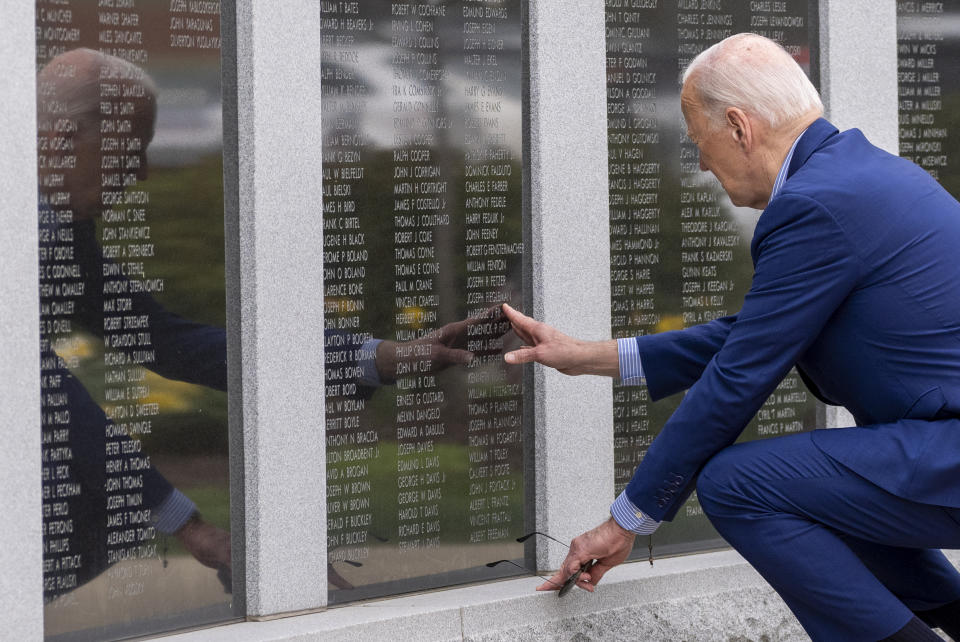 President Joe Biden reaches to touch the name of his uncle Ambrose J. Finnegan, Jr., on a wall at a Scranton war memorial, Wednesday, April 17, 2024, in Scranton, Pa. His uncle died in WWII. (AP Photo/Alex Brandon)