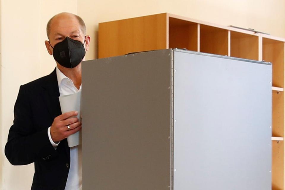 Olaf Scholz, Social Democratic Party candidate for chancellor, walks behind a polling booth to cast his vote (REUTERS)