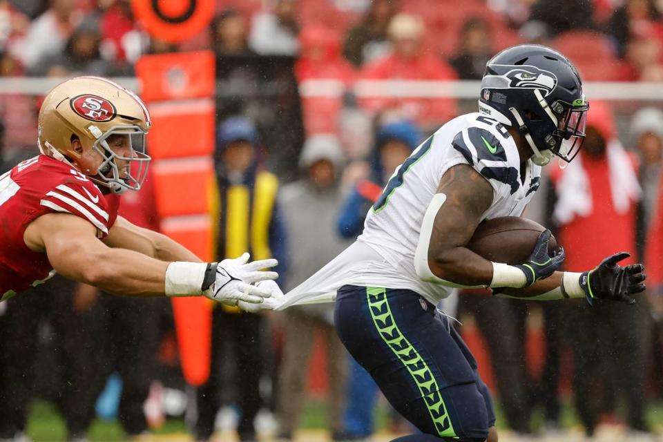 San Francisco 49ers defensive end Nick Bosa, left, grabs the jersey of Seattle Seahawks running back Rashaad Penny during the second half of an NFL football game in Santa Clara, Calif., Sunday, Sept. 18, 2022. (AP Photo/Josie Lepe)