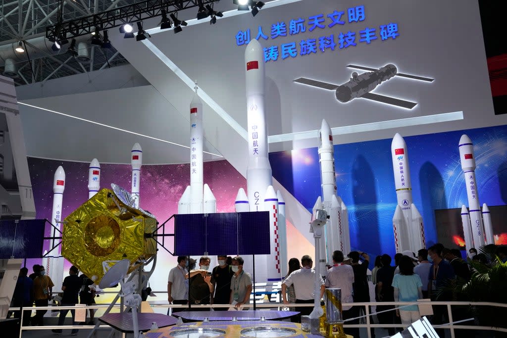 File: Visitors view replica space launch rockets including the first generation rockets for manned launch produced by China Aerospace Science and Technology Corporation  at an exhibition on 29 September in Zhuhai (AP)