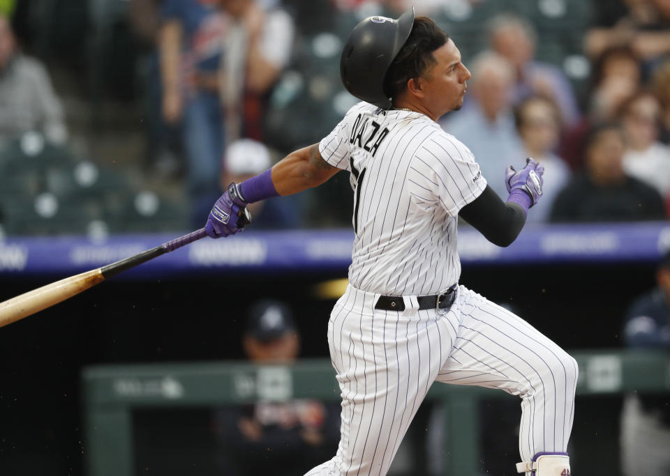 Colorado Rockies' Yonathan Daza loses his helmet while swinging at a pitch from Atlanta Braves starting pitcher Max Fried during the first inning of a baseball game Tuesday, April 9, 2019, in Denver. Daza was making his debut in the majors. (AP Photo/David Zalubowski)