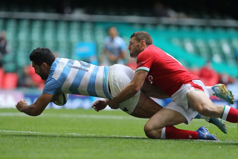 El centro de Argentina Jerónimo de la Fuente se lanza sobre la línea para anotar un try cuando el ala de Gales Jonah Holmes (R) no logra abordarlo durante el test entre Gales y Argentina