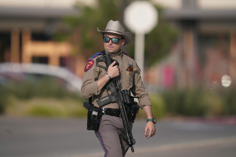 A law enforcement officer walks at a shopping center after a shooting Saturday, May 6, 2023, in Allen, Texas. (AP Photo/LM Otero)