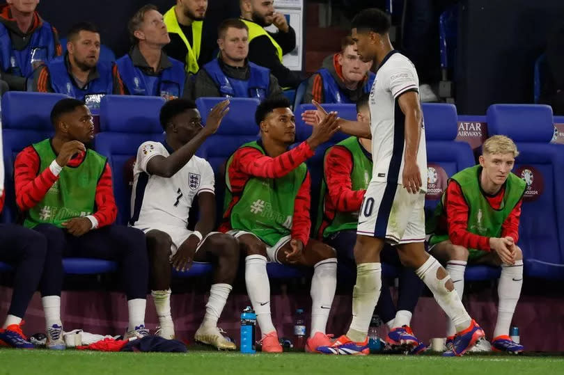 Jude Bellingham (R) of England shakes hands with teammates Ollie Watkins (C)